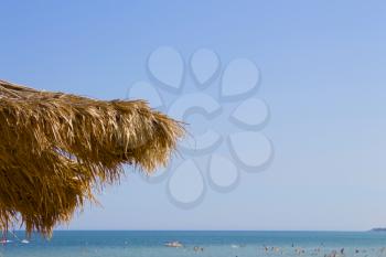 Beach and sun straw umbrella on the beach