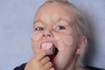 Portrait of beautiful small girl eating sweetmeat