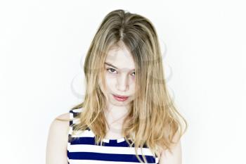 Cute teenager girl with blond long hair and big eyes on white wall in striped clothes