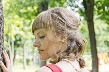 Horizontal portrait of profile girl with blond hair on green background