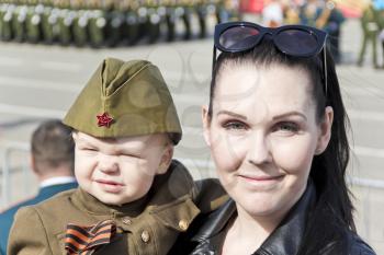 Samara, Russia - May 9, 2017: Mother with baby in soldier costume at the honor of annual Victory Day