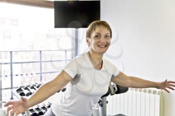 Smiling elderly woman with a short haircut in the gym