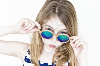 Blond girl are standing near white wall with green sunglasses