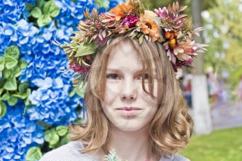 Portrait of cute blond girl fourteen years old in flowers wreath
