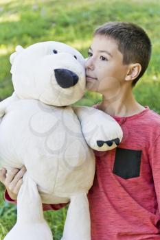 Teenager boy in pink with big white bear