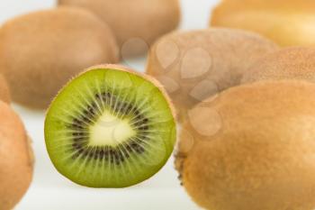 Green kiwi slices and whole kiwi fruit