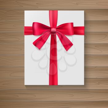 White package with a large red bow. A holiday gift box close-up, top view on wooden background. Vector white square gift box with shiny red satin bow, ribbon.
