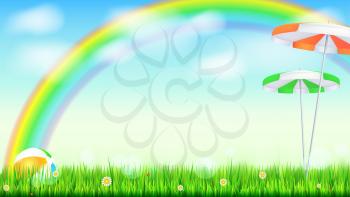 Summer background. Big bright rainbow above green field. Juicy grass, daisy flowers, ladybugs in grass on backdrop from blue sky with clouds. Landscape with Solar umbrella and inflatable ball.