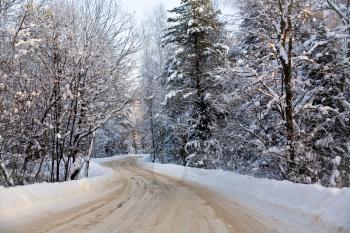 a turn of a winter road in snow forest