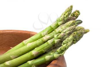 fresh green asparagus in wooden bowl