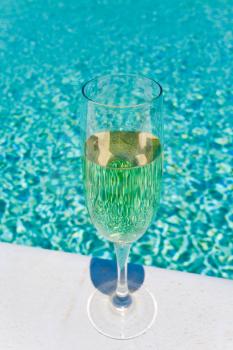 glass of white wine on pool board outdoor