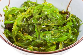 chuka salad - seaweed salad with sesame seeds in ceramic bowl close up
