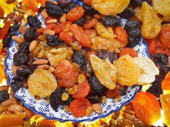 top view of oriental dessert - dried sweet fruits on arabic plate close up
