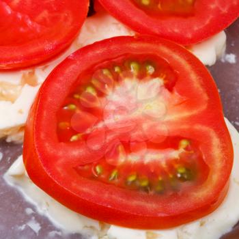 sliced tomatoes and brined cheese on ceramic plate close up