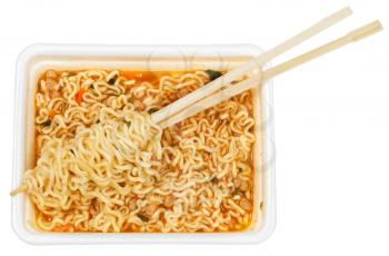 eating of prepared instant ramen by wooden chopsticks from foam cap isolated on white background