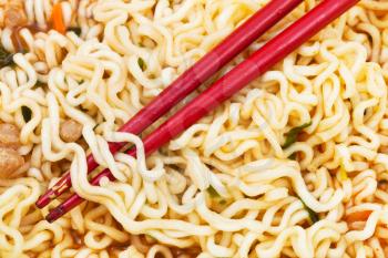 red chopsticks on cooked instant ramen close up