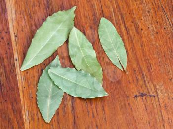 few dried aromatic bay leaves on wooden table