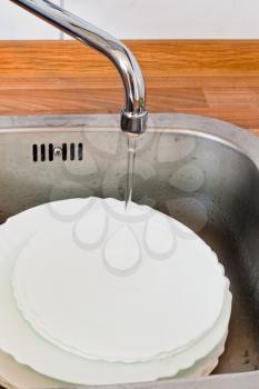 wash-up in metal washbasin in kitchen