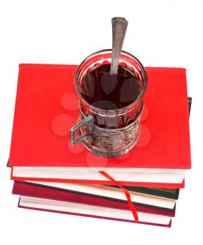 top view of glass of tea on stack of books isolated on white background
