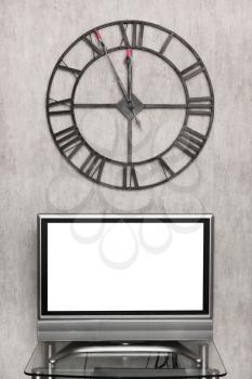 five minutes to midnight on wall clock under blank white screen of TV set