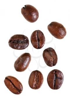 several falling roasted coffee beans isolated on white background