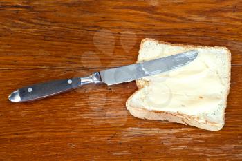 bread and butter sandwich with table knife on wood board