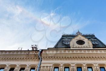 Rainbow in blue sky over urban building