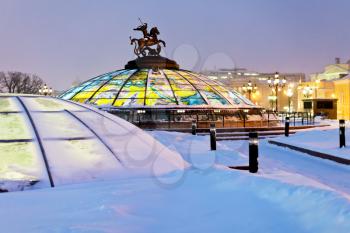snow in Moscow - glass cupola with Saint George and the Dragon on Manege square in winter snowing evening