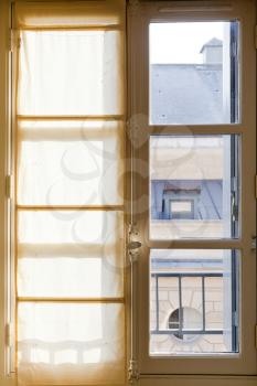 white textile drapes on sunny window