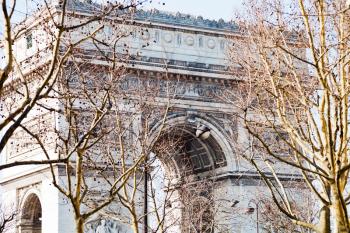 view of Triumphal Arch in Paris in early spring day through tree