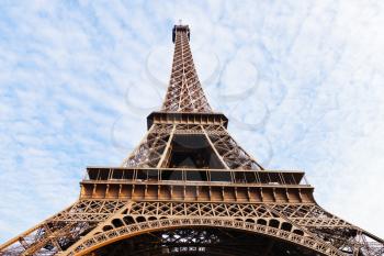 bottom view of Eiffel tower in Paris under blue sky and white clouds