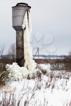 frozen water tank house in country field in winter day