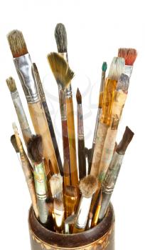 used artistic paintbrushes in wooden cup isolated on white background