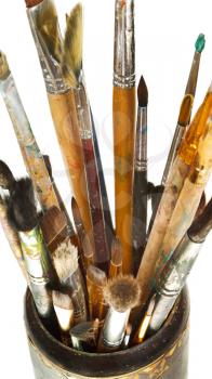 top view of used artistic paintbrushes in wooden cup isolated on white background