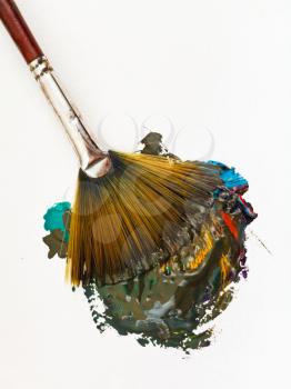 fan paintbrush blends multicolored watercolor paints close up