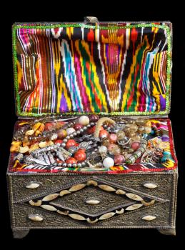 ancient east treasure chest with antique jewelry isolated on black background