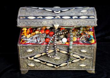 ancient east treasure chest with antique jewelry on black textile