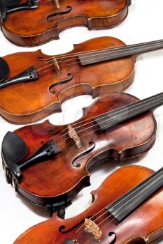 several used fiddles on white background close up