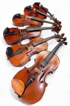 different sized fiddles on white background close up