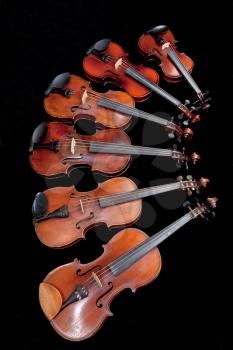 different sized violins on black background