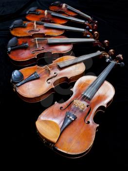 six violins with black background close up