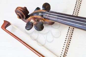 fiddle bow and scroll on music book close up