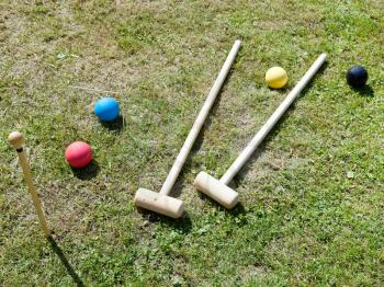 wooden croquet equipment for game of croquet on green lawn in summer day