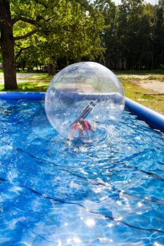 girl play in water ball in open swimming pool