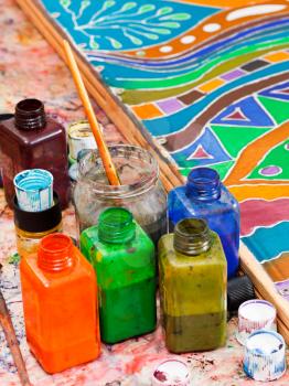 paintbrushes and bottles with pigments for cold batik