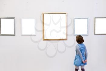 girl sees a picture frames in art gallery