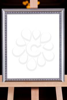 silver picture frame with white cut out canvas on easel