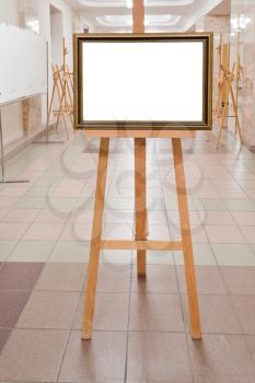picture frame with white cut out canvas on easel in art gallery