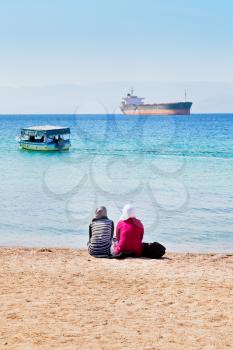 people on urban beach in Aqaba town, view on Aqaba gulf