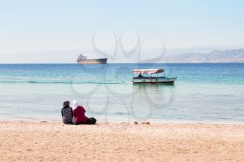 people on urban beach in Aqaba town, view on Aqaba gulf